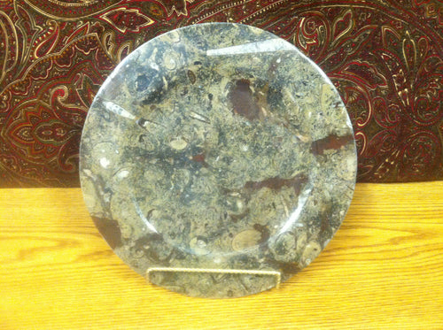 Round plate or bowl made of prehistoric fossils. Ammonite and Orthoceras art